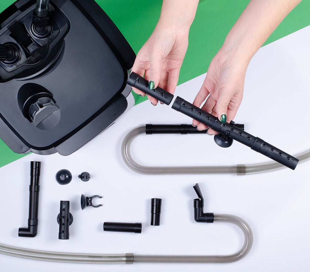 person setting up a canister filter for aquarium
