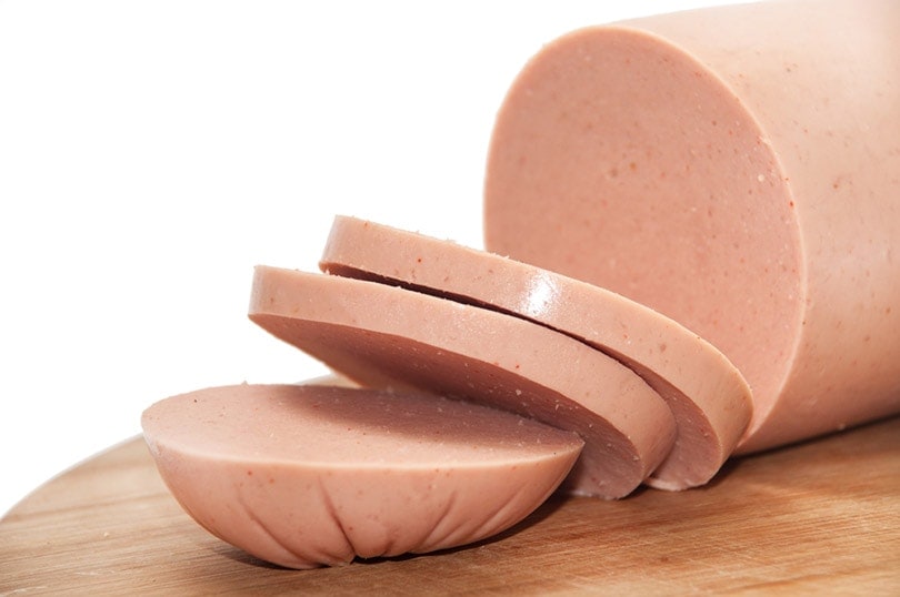 sliced bologna on wooden board
