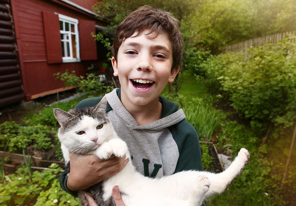 boy carrying a cat