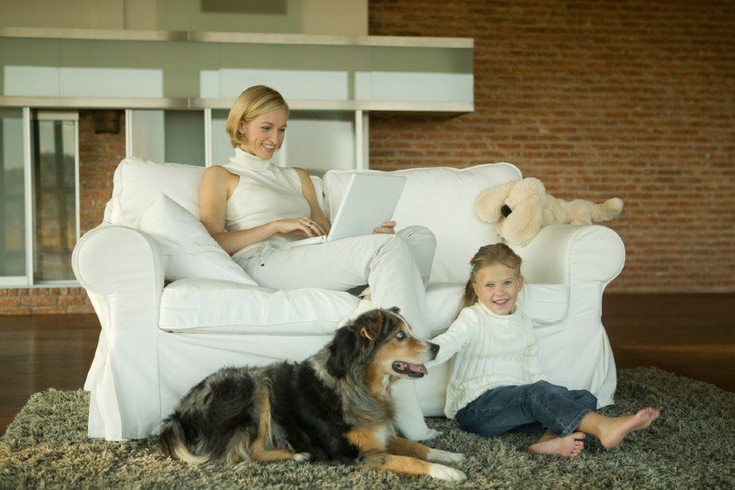 Mother and daughter relaxing with australian shepherd