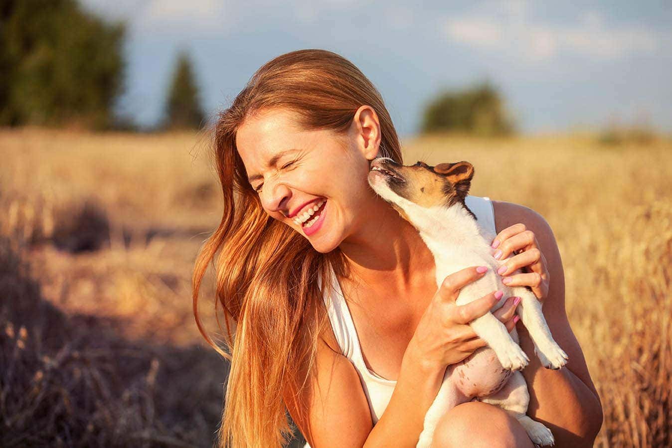 dog licking woman's ear