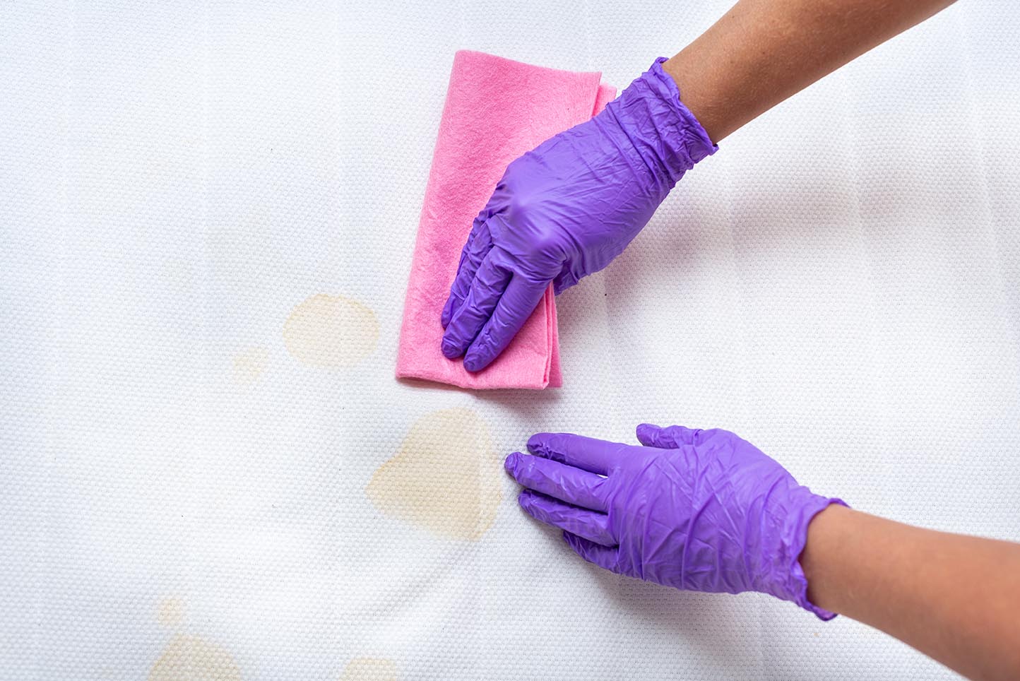 person removing dry stain in the mattress