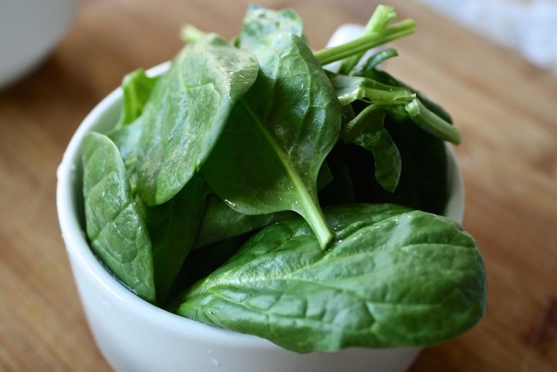 A bowl of spinach on the table