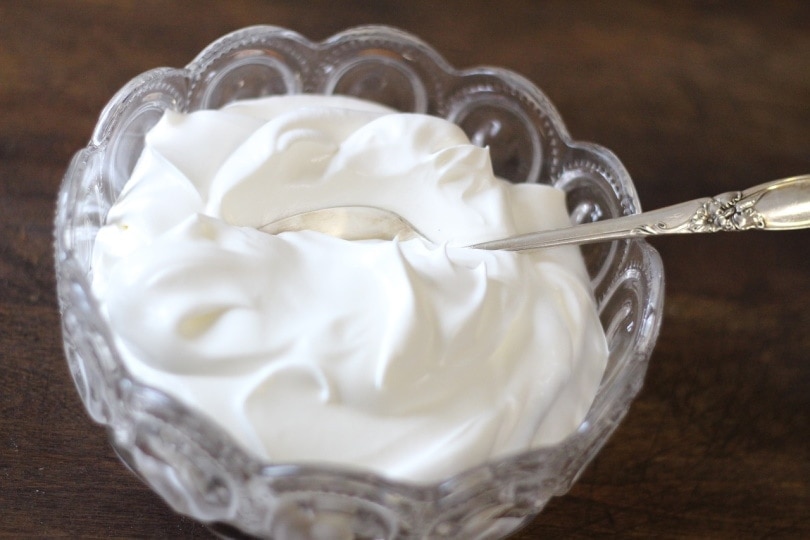 Whipped cream in a bowl with a spoon