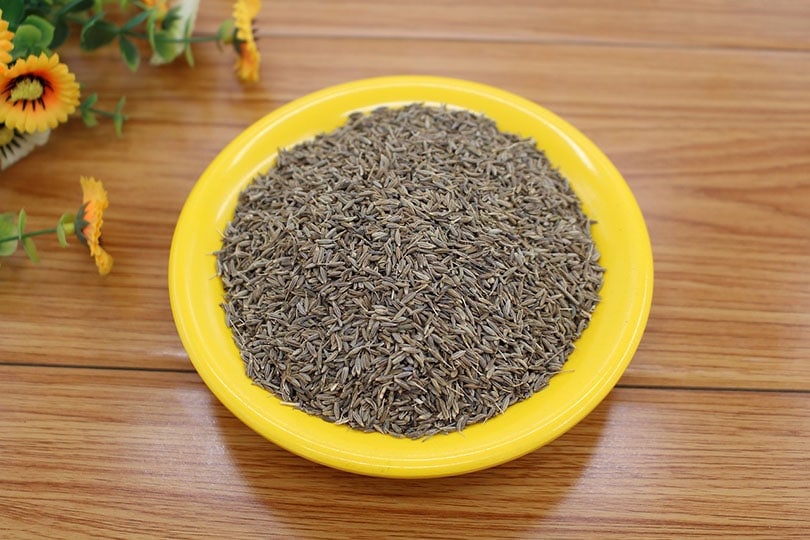 cumin spice on yellow plate on a wooden table