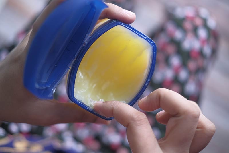 hand scooping some vaseline from the jar