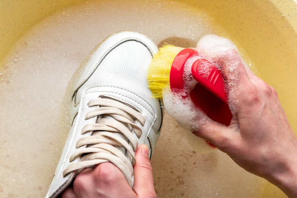 Sneakers in a wash basin with soapy water