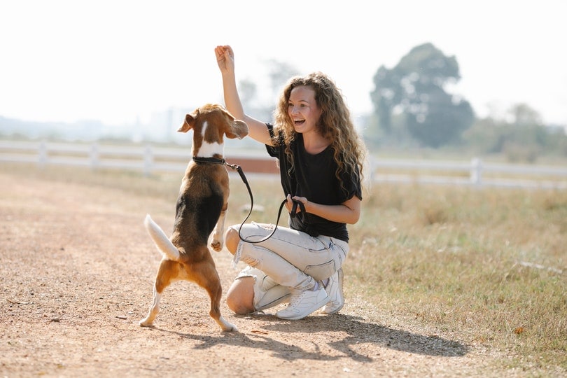 happy woman giving treat to her dog