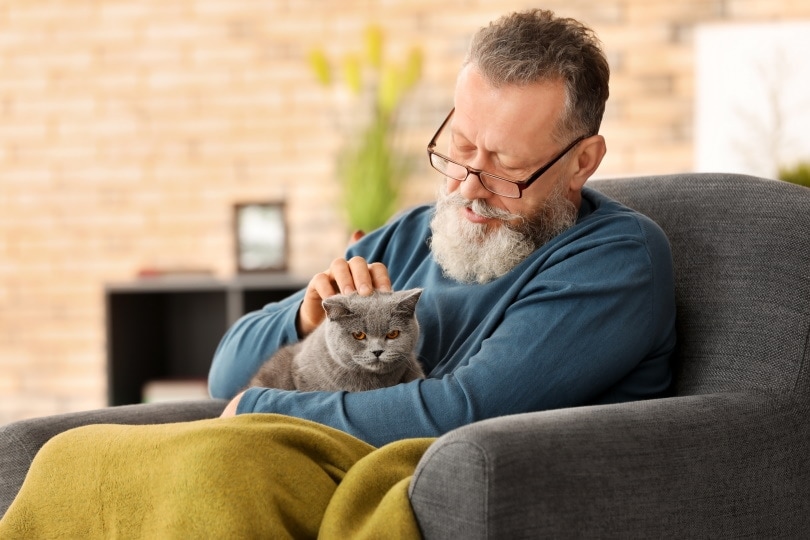 old man holding cat
