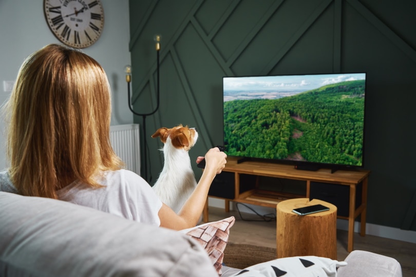 woman watching tv with her dog