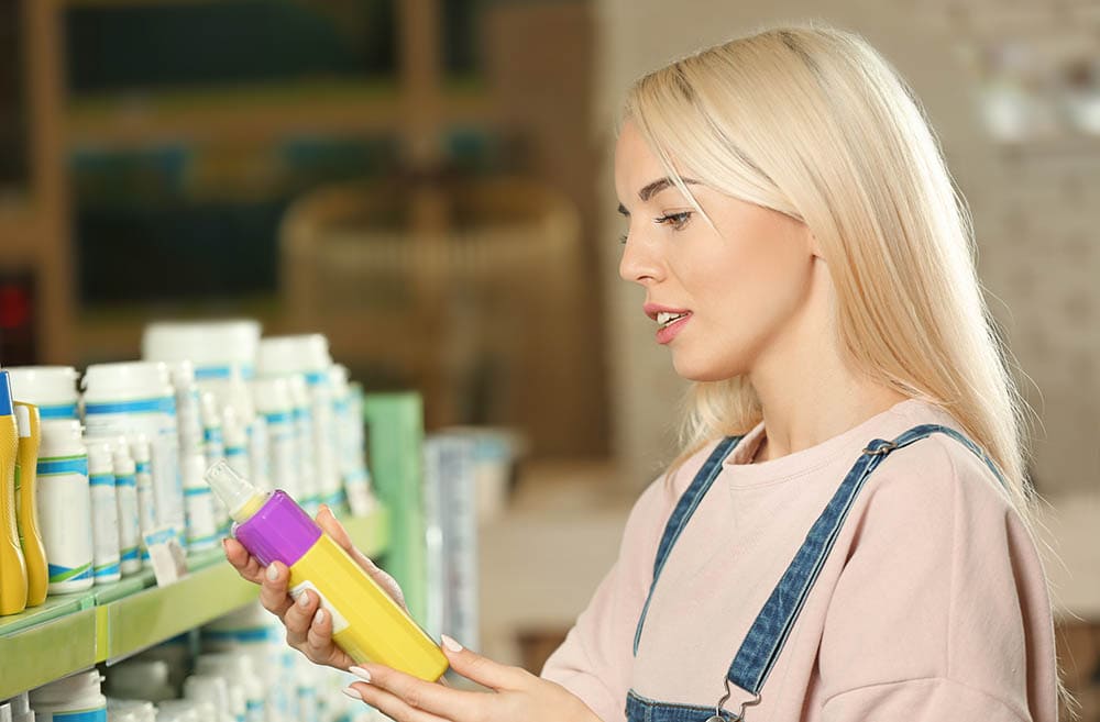 young woman selecting a pet shampoo