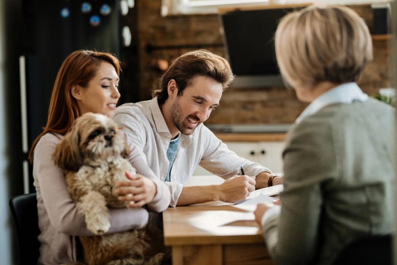 man signing pet insurance policies