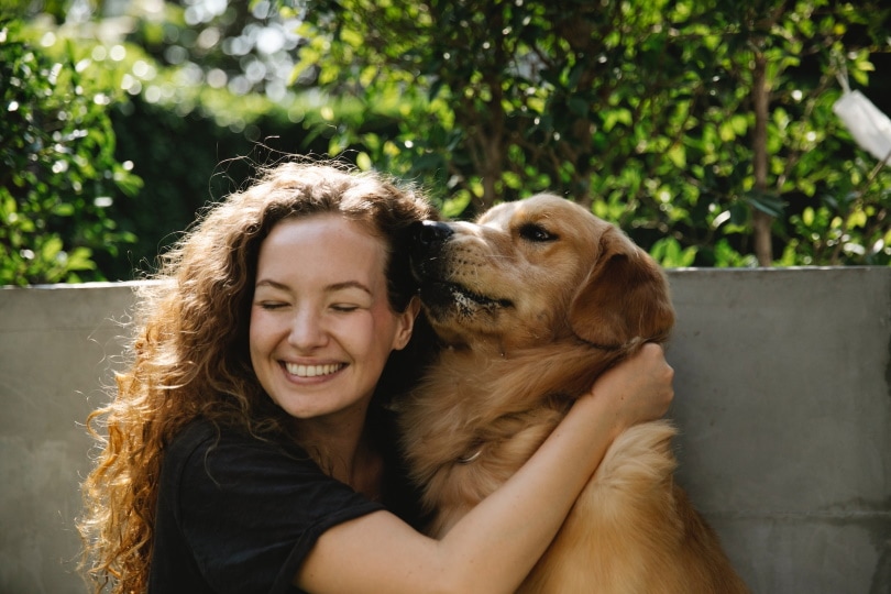 Golden retriever licking a woman's face