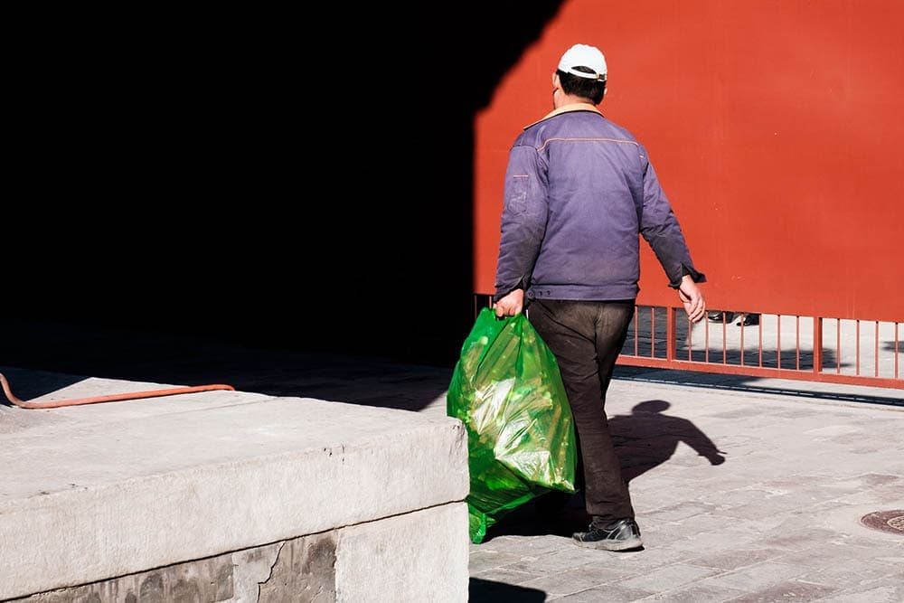 man carrying a garbage bag