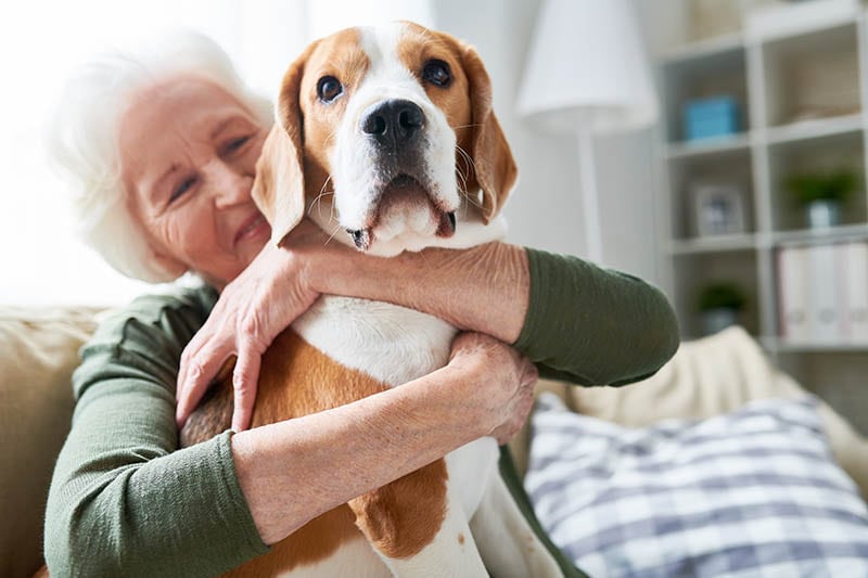 Senior woman hugging pet dog