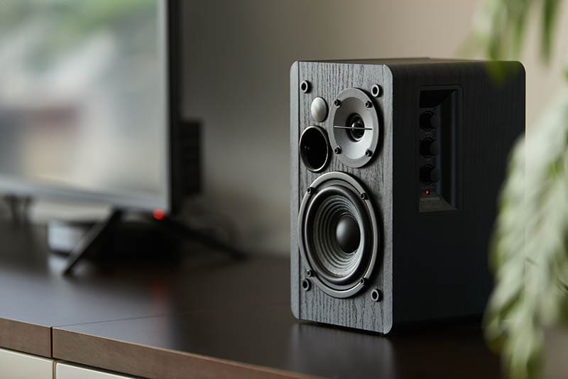 bookshelf speaker with digital TV and set top box on a TV stand