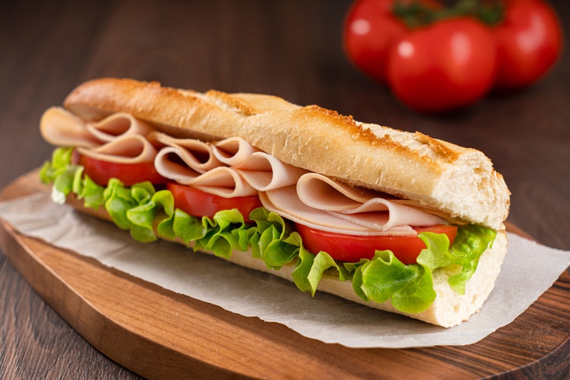 A turkey sandwich with lettuce and tomatoes