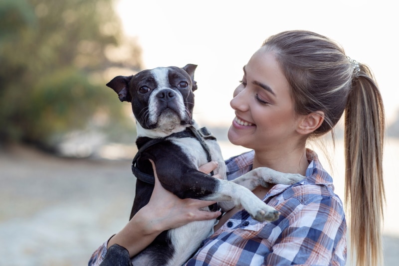 woman holding her boston terrier