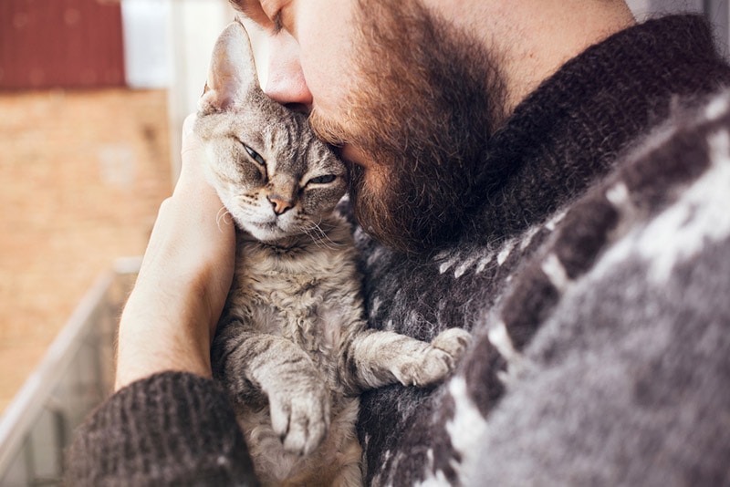 bearded man cuddling his cat
