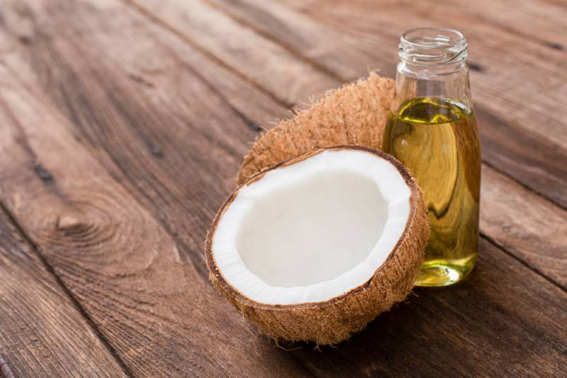 Coconut fruit and coconut oil isolated on wood table background