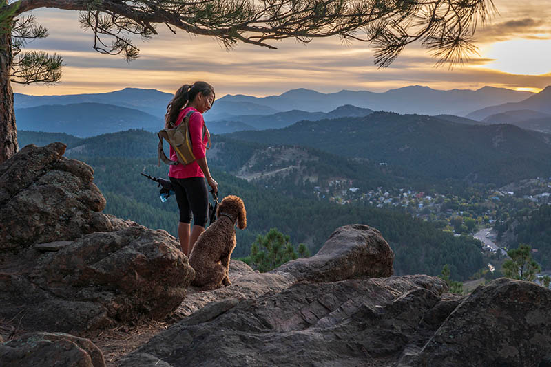 woman is hiking with a dog in the Rocky Mountains of Colorado
