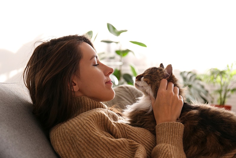 young woman holding her siberian cat