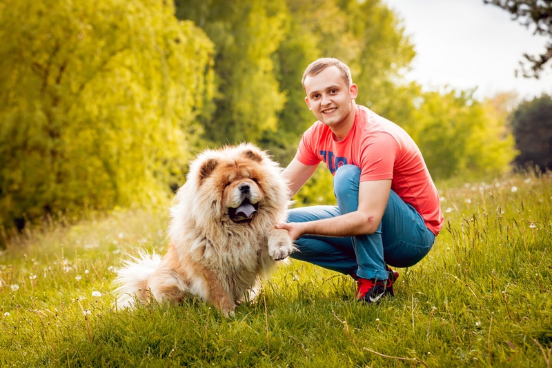 man with chow chow dog in the park