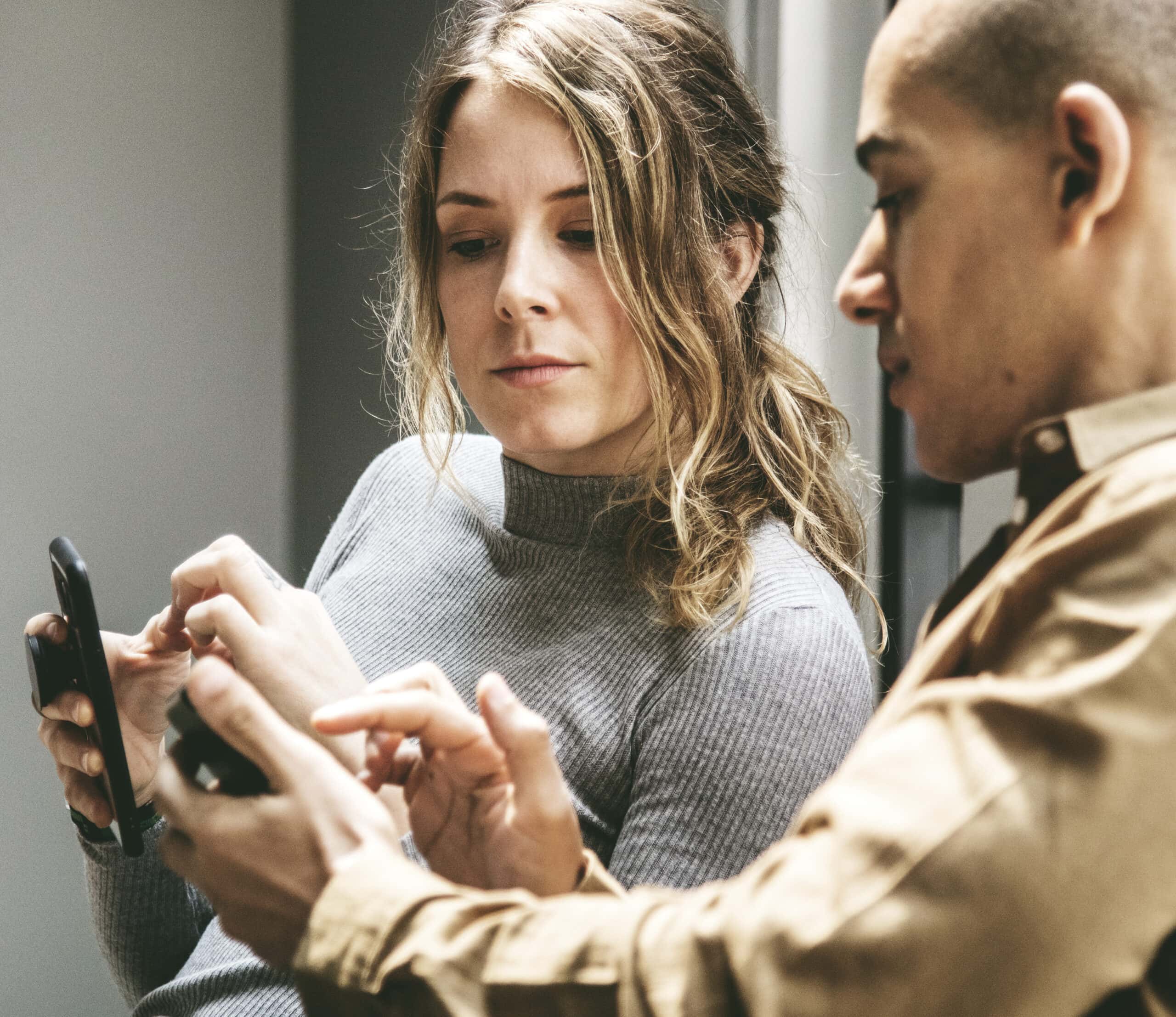 Man showing his smartphone to his friend
