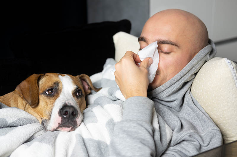 sick man lying in bed with his dog