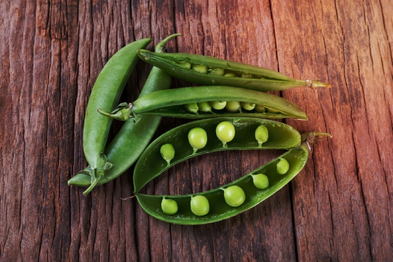 sugar snap peas on wooden background