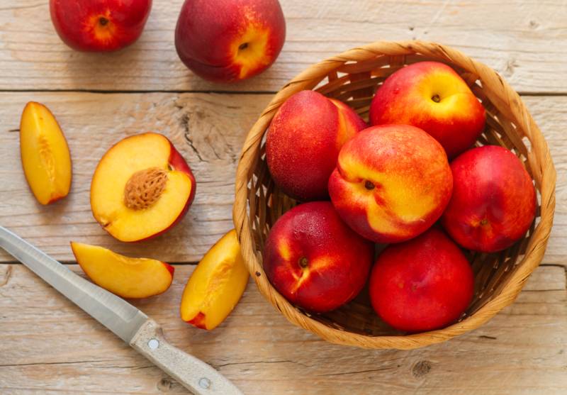 Ripe juicy organic nectarines in a wicker basket