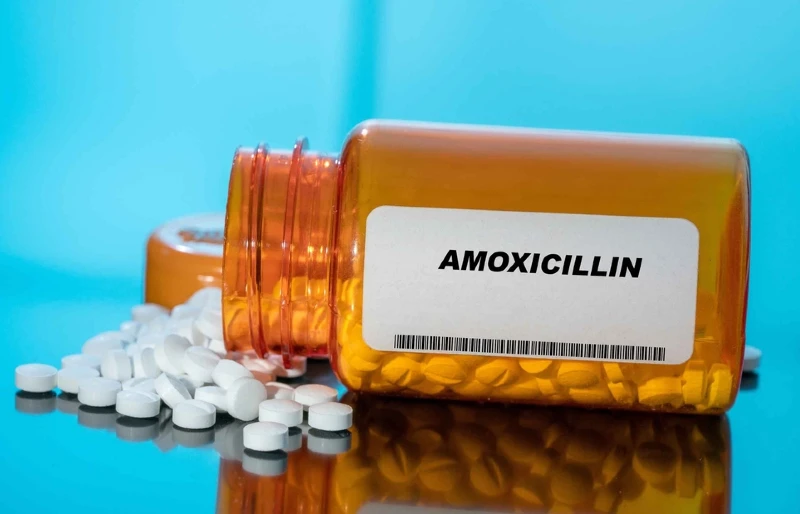 amoxicillin tablets spilling out of drug or medicine bottle