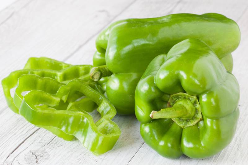 green pepper on a white wooden background