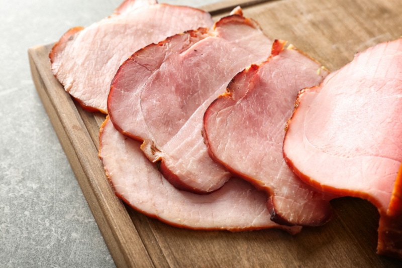 sliced baked ham on wooden board