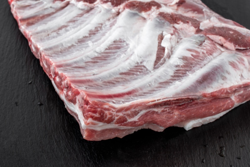 Raw pork rib slab on wooden table