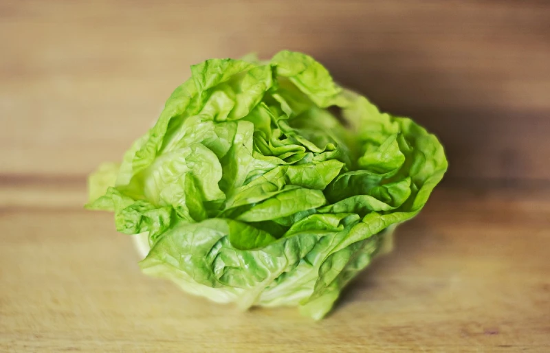 a head of lettuce on a wooden surface