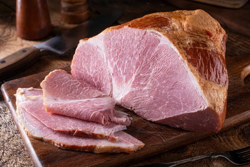 delicious naturally smoked ham on a rustic wood cutting board