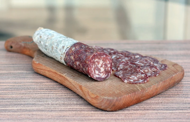 sliced salami on top of wooden cutting board
